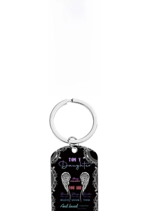 Detail of black metal keychains with floral and wing designs and inspirational quotes