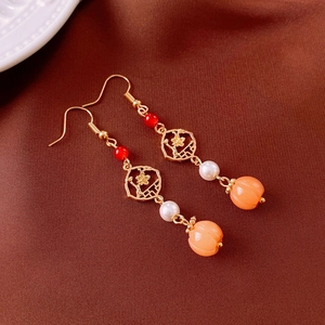 Detail of flower pearl tassel earrings with red bead and golden plum blossom frame