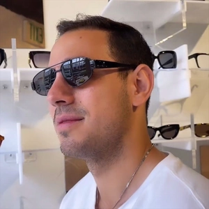 Fashionable double bridge metal pilot sunglasses worn by male model in a store