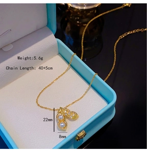 Vue détaillée du collier pendentif cacahuète doré avec perle blanche en coffret