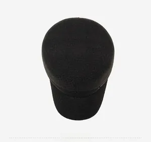 Top view of a black wool flat top military style hat for elderly men on grey background