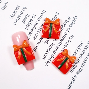 Makroaufnahme von 3D-Harz-Geschenkbox-Nageldekorationen mit orangefarbenen Schleifen