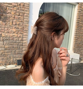 Detail of pink butterfly hair claw clip with matte finish worn by model on long hair