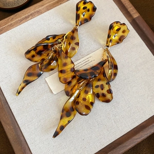 Detail view of retro leopard print acrylic petals on bohemian amber dangle earrings