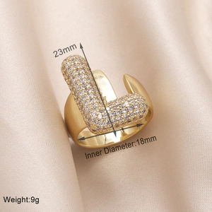 Detail view of gold letter L ring with cubic zirconia on silk, showing 18mm diameter