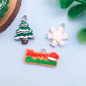 Detail of resin Christmas tree, snowflake and Merry Christmas pendants with metal hooks