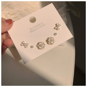 Detail view of 6-piece earring set featuring camellia flowers, bows and elegant pearls