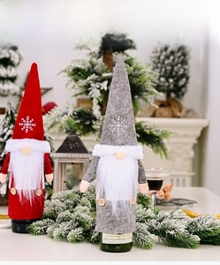Detail of Christmas gnome wine bottle covers with white beard and snowflake pattern