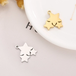 Detailed view of gold and silver stainless steel triple star charms on a white plate