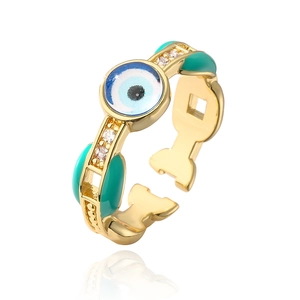 Close-up of 18K gold plated evil eye ring with green enamel and white zircon accents