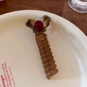 Brown telephone wire hair tie with a cute flower and red bead top, sweet sweet styling.