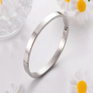 Close-up of polished silver titanium steel bangle showing hinge and secure clasp detail