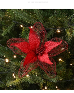 Detail of red mesh Christmas flower with glitter on a tree with warm bokeh lights