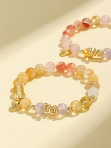 Macro detail of purple amethyst and pink quartz beaded bracelet with gold snake charm