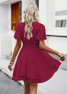 Détail d'une mini-robe rouge foncé avec dos en V et ourlet évasé à volants élégants