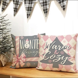 Detail of pink and grey winter pillows with 'WINTER blessings' text on wooden bench