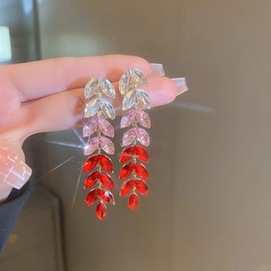 Detail of silver needle earrings with leaf-shaped gradient crystals in red and pink