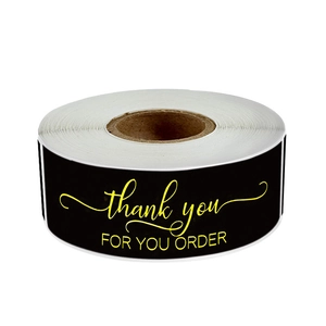 Roll of black rectangular 'Thank You For Your Order' stickers with gold lettering on white base