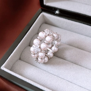 Detailed macro view of double-layer pearl elastic ring with crystal-set flower accents