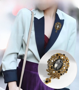 Detail of vintage rhinestone brooch with black gemstone and water drop pendant accessory