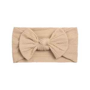 Detailed view of beige cable-knit texture and soft knot on elastic baby headband