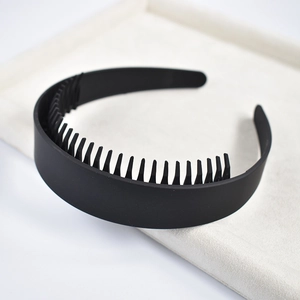 Detail view of black non-slip wide headband with inner teeth on a beige velvet tray