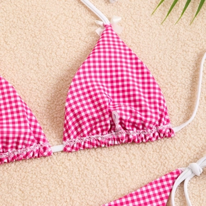 Detailed close-up of pink gingham bikini top with bow accents and ruffled edges