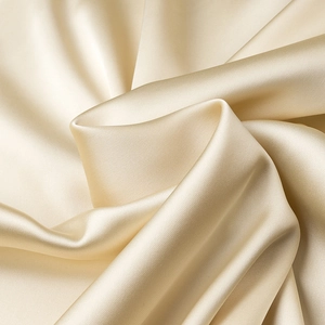 Macro shot of luxurious champagne gold satin fabric with elegant silky texture and sheen