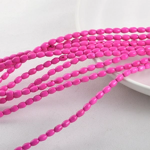 Close-up of pink oval turquoise beads arranged on white ceramic for DIY jewelry making
