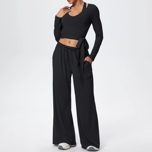 Détail du haut cache-cœur noir à manches longues et du pantalon de yoga évasé