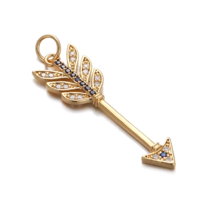 Detailed view of golden arrow pendant with inlaid blue and clear zircon stones
