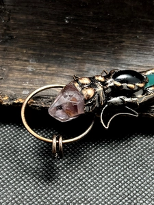 Detailed macro of vintage bronze moon pendant with amethyst and colorful agate stones