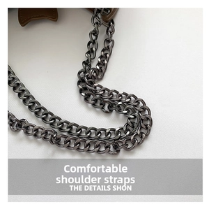 Detail of gunmetal chain strap with ring clasp on a creative bat-shaped shoulder bag