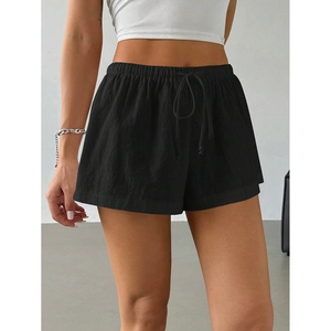 Detailed close-up of drawstring elastic waistband and natural texture of black summer shorts