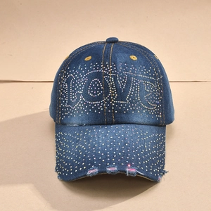 Close-up of rhinestone LOVE lettering and distressed details on denim baseball cap