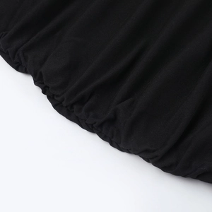 Gros plan détaillé sur la texture du mesh noir et les coutures froncées de la robe