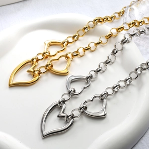 Macro shot of gold and silver heart-shaped pendant necklaces on a ceramic tray