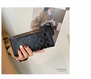 Detail einer schwarzen Kunstleder-Clutch mit silbernen Nieten in geometrischem Muster