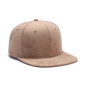 Beige baseball cap with minimalist floral line art patterns on a clean white background