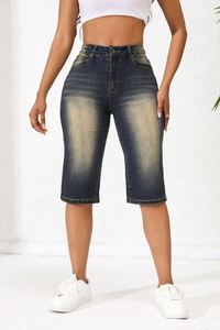 Close-up of high waist denim shorts featuring vintage washed finish and single button fly