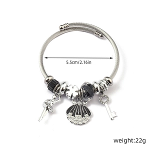 Detailed view of stainless steel charm bracelet with ballet dancer and clover pendants