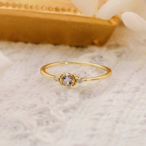 Close-up of minimalist S925 silver gold-plated ring with round purple tanzanite gemstone