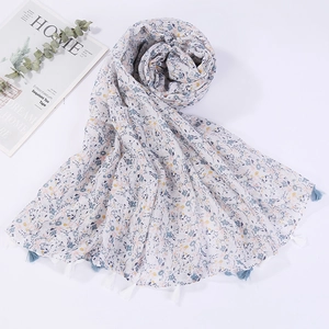 Detailed view of the lightweight floral print scarf featuring delicate tassel fringe edges