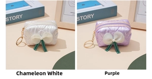 Detailed view of quilted bow coin purses with pearls and gold keychains in white and purple