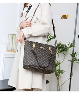 Detailed view of brown tote bag with M-pattern texture and gold hardware on a beige trench coat