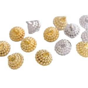 Textured gold and silver Christmas ornament caps with hanging loops on white background