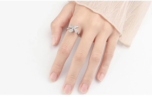 Macro shot of silver flower spinner ring with zircons worn on a model's finger