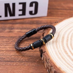 Brown braided leather bracelet with metal beads and magnetic clasp on wooden base