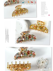 Detail of Christmas acrylic hair claws with embedded glitter stars and festive patterns