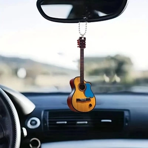 Detailed macro view of a wood-grain acoustic guitar pendant hanging in a car interior